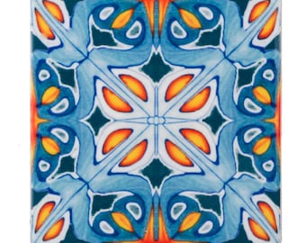 May include: Square ceramic tile with a symmetrical floral design. The tile features a pattern of blue, orange, and white shapes against a dark teal background. The design is reminiscent of traditional decorative tiles.
