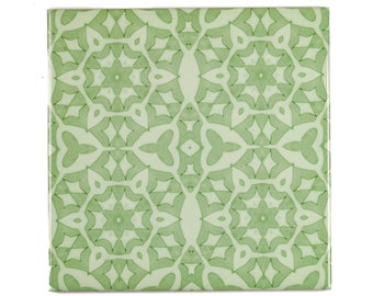 May include: A green ceramic tile with a repeating geometric pattern of stars and leaves.