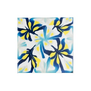 May include: A square ceramic tile with a blue and yellow floral pattern. The tile has a white background and features stylized blue and yellow flowers with white centers.