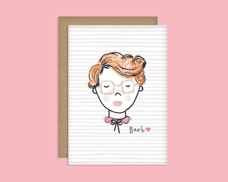May include: A greeting card with a cartoon illustration of a person with red hair wearing glasses and a pink collar. The text "Barb" is written below the illustration with a small pink heart.