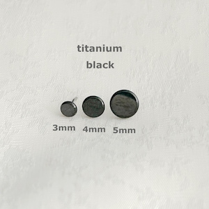 Op de afbeelding: Drie zwarte titanium oorstekers in de maten 3 mm, 4 mm en 5 mm. De oorbellen zijn rond en hebben een matte afwerking. De tekst "titanium black" staat boven de oorbellen.