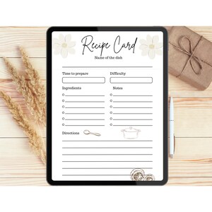 Puede incluir: Una tableta digital blanca con una plantilla de tarjeta de receta. La plantilla tiene secciones para el nombre del plato, el tiempo de preparación, la dificultad, los ingredientes, las notas y las instrucciones. También hay ilustraciones de una cuchara y una olla.