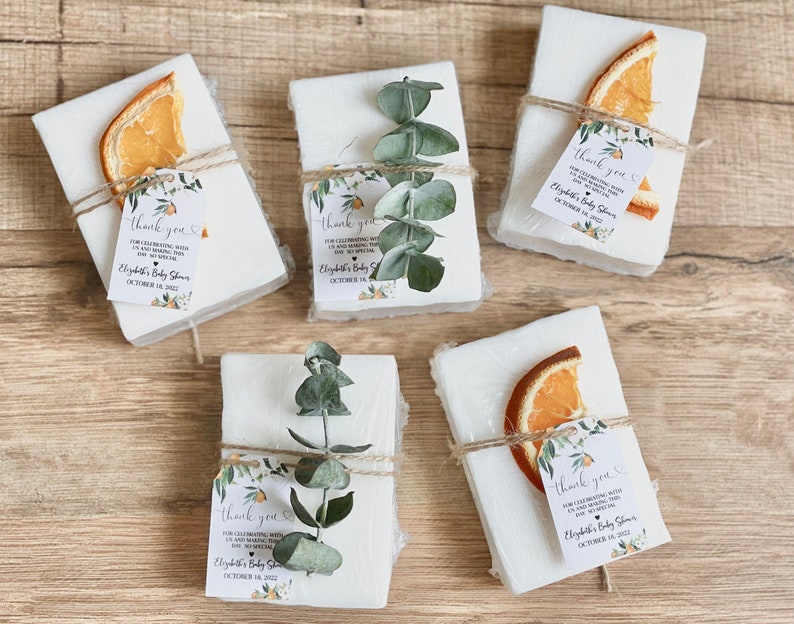 Baby shower soap favors with orange themed customized tag and the option of an orange slice or eucalyptus sprig tied onto the soap favor