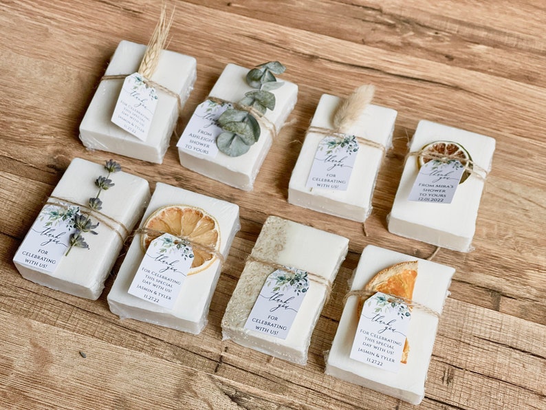 Soap bars for weddings or bridal shower favors with a customized tag with greenery design and multiple soap topping options.