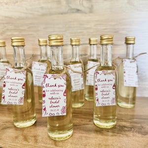 ”that’s Amore” bridal shower olive oil favors in a clear glass bottle with gold lid