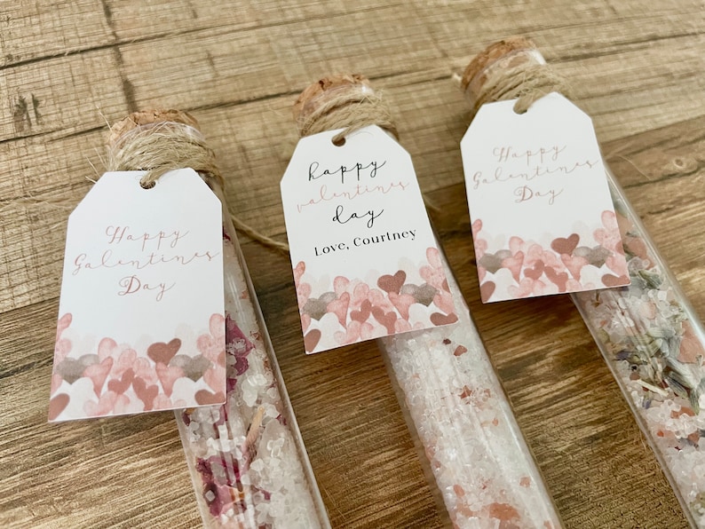 May include: Three glass test tubes filled with bath salts and dried flowers, each with a small white tag tied with twine. The tags have handwritten messages that say "Happy Valentine's Day" and "Happy Valentine's Day, Love, Courtney".