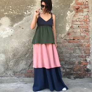 May include: A tiered maxi dress with a dark blue, green, and pink color scheme. The dress has a fitted bodice and a flowing skirt.