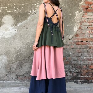 May include: A tiered maxi dress with a green top layer, a pink middle layer, and a navy blue bottom layer. The dress has a criss-cross strap design in the back.