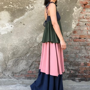 May include: A tiered maxi dress with a dark blue, green, and pink color scheme. The dress has a sleeveless bodice and a tie at the back.