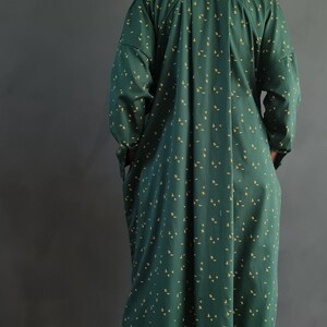 May include: A green and yellow patterned shirt and pants set. The shirt has a long sleeve and a collared neckline. The pants are long and have a straight leg.