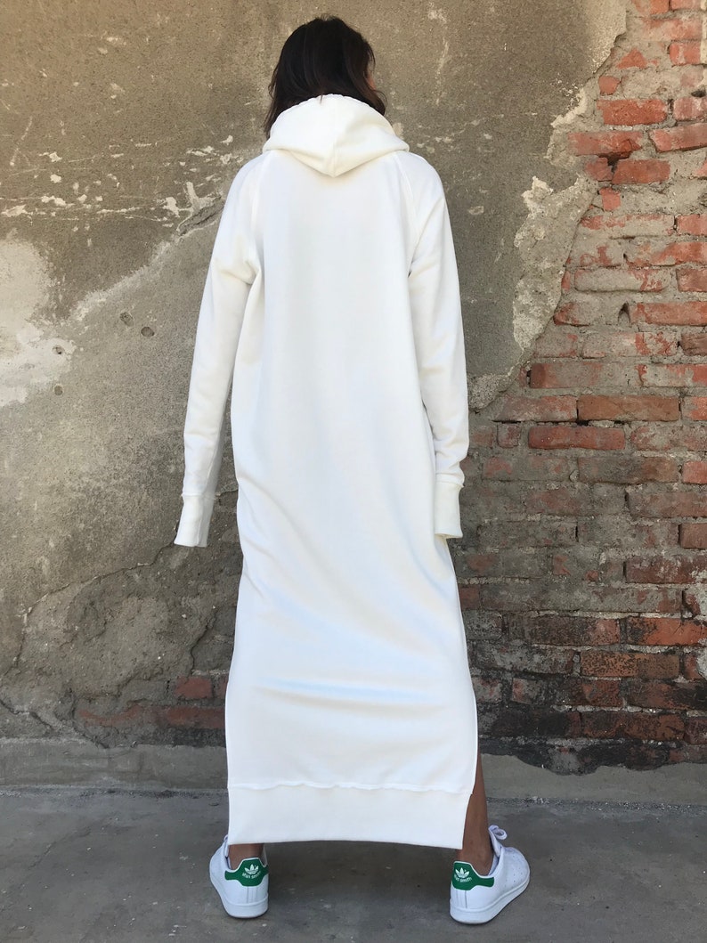 Pu&ograve; includere: Un vestito bianco con cappuccio a felpa con maniche lunghe e uno spacco laterale. Il vestito &egrave; realizzato in un tessuto morbido e confortevole e ha una vestibilit&agrave; rilassata.