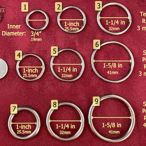 May include: Nine silver metal rings of different sizes, labeled with numbers 1 through 9. The rings are on a red background. The rings are measured in inches and millimeters. The rings are described as textured or smooth polished. The rings are 3 mm or 4.5 mm thick.