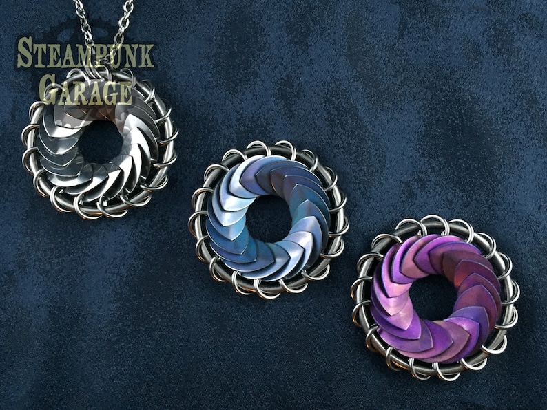 May include: Three silver chainmail rings with a swirling pattern. The rings are in different colors: silver, blue, and purple.