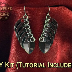 May include: DIY kit for making a pair of silver-toned earrings with a chain and multiple leaf-shaped charms. The kit includes a tutorial.  The earrings are displayed on a red fabric background.  DIY KIT (TUTORIAL INCLUDED!)