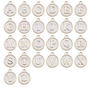 May include: A set of 26 gold-colored metal alphabet letter charms. Each charm is a circle with a white background and a gold letter in the center. The letters are in alphabetical order from A to Z.