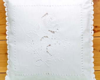 May include: White pillow with a crocheted border and an embroidered rose design.