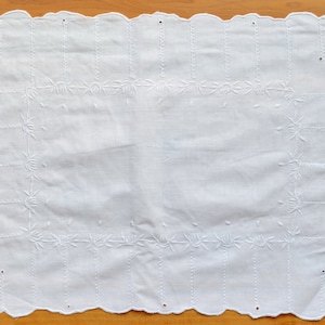 Può includere: Fazzoletto di cotone bianco con bordo smerlato e ricamo floreale.