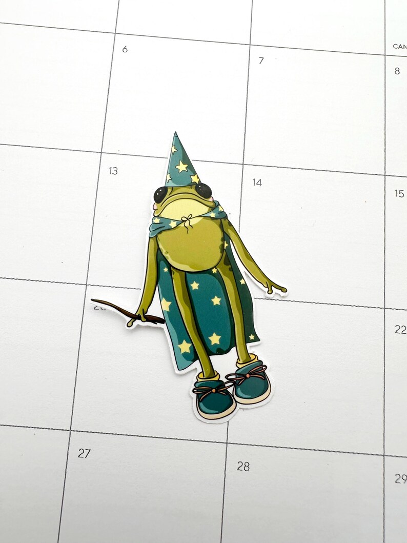 Frog wearing star covered cape and wizard hat.