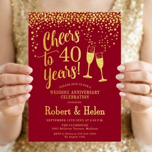 Könnte beinhalten: Eine rote Hochzeitseinladung mit goldenem Text und Akzenten. Die Einladung lautet "Cheers to 40 Years!" und enthält Details für eine Feier zu Ehren von Robert & Helen. Zwei Champagnergläser sind abgebildet.