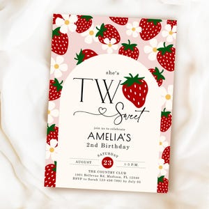 May include: A rectangular birthday invitation card featuring a light pink background with a pattern of red strawberries and white flowers. A central white arch contains the text she's TWO Sweet, Amelia's 2nd Birthday, Saturday August 23, 1-3 P.M.