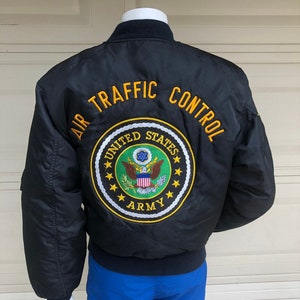 May include: Black bomber jacket with "AIR TRAFFIC CONTROL" and "UNITED STATES ARMY" embroidered on the back.