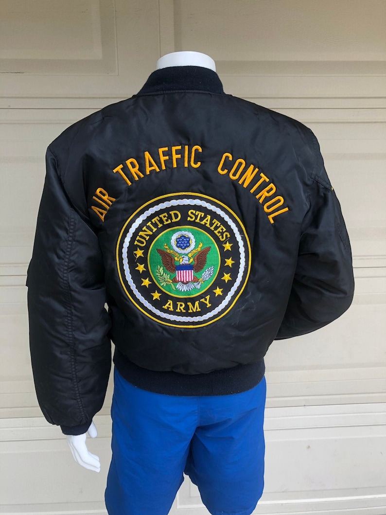 May include: Black bomber jacket with "AIR TRAFFIC CONTROL" and "UNITED STATES ARMY" embroidered on the back.