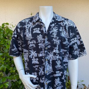 May include: A black short-sleeved button-up shirt with a white palm tree print.