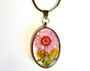 Collar de aster rosa prensado hecho a mano: bisel ovalado de bronce y cordón de cuero.