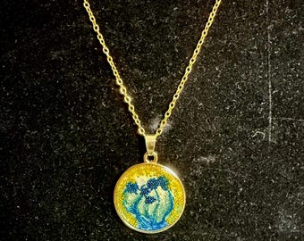 Collar con colgante abstracto de resina azul perlada, bisel dorado y microperlas