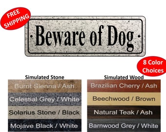 May include: A rectangular sign with the text "Beware of Dog" in black lettering on a simulated stone background. The sign is available in eight color choices, including Burnt Sienna / Ash, Celestial Grey / White, Solarius Stone / Black, Mojave Black / White, Brazilian Cherry / Ash, Beechwood / Brown, Natural Teak / Ash, and Barnwood Grey / White.