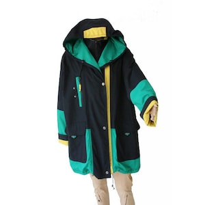 May include: A black hooded jacket with green and yellow accents. The jacket has a zipper closure and two pockets.