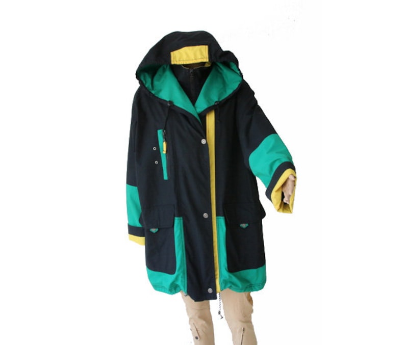 May include: A black hooded jacket with green and yellow accents. The jacket has a zipper closure and two pockets.