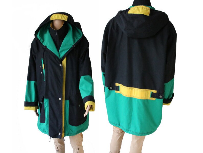 May include: A black, green, and yellow hooded jacket with a zipper closure and two pockets. The jacket has a contrasting color design with a green and yellow panel at the bottom.