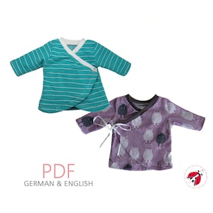 Könnte beinhalten: Zwei Wickeltops für Babys, einer türkis mit weißen Streifen und einer lila mit einem schwarzen Schaf-Druck. Beide Oberteile haben einen Wickelstilverschluss und sind aus weichem Stoff gefertigt. PDF-Schnittmuster zum Nähen.