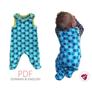 Può includere: Un body per neonato a pois blu e bianchi con bordi verdi e chiusure a pressione. Il body è senza maniche e ha un design a piede pieghevole. Il body è mostrato su uno sfondo bianco. PDF TEDESCO & INGLESE.