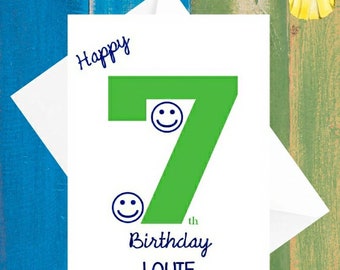 May include: A white card with blue text that says "Happy 7th Birthday LOUIE". The number 7 is green and has two smiley faces on it.