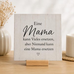 Peut inclure: Panneau en bois clair avec texte allemand noir "Eine Mama kann Vieles ersetzen, aber Niemand kann eine Mama ersetzen". Le panneau est soutenu par un petit support en bois et comporte un cœur.