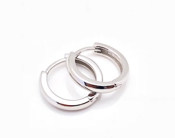 May include: A pair of silver hoop earrings. The earrings are simple and elegant, and they would be a great addition to any jewelry collection.