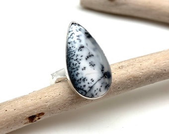 May include: A teardrop-shaped ring with a black and white dendritic agate stone set in sterling silver.