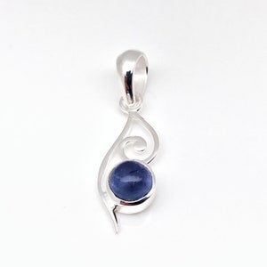 Op de afbeelding: Een zilveren hanger met een blauwe edelsteen in een swirl-ontwerp.