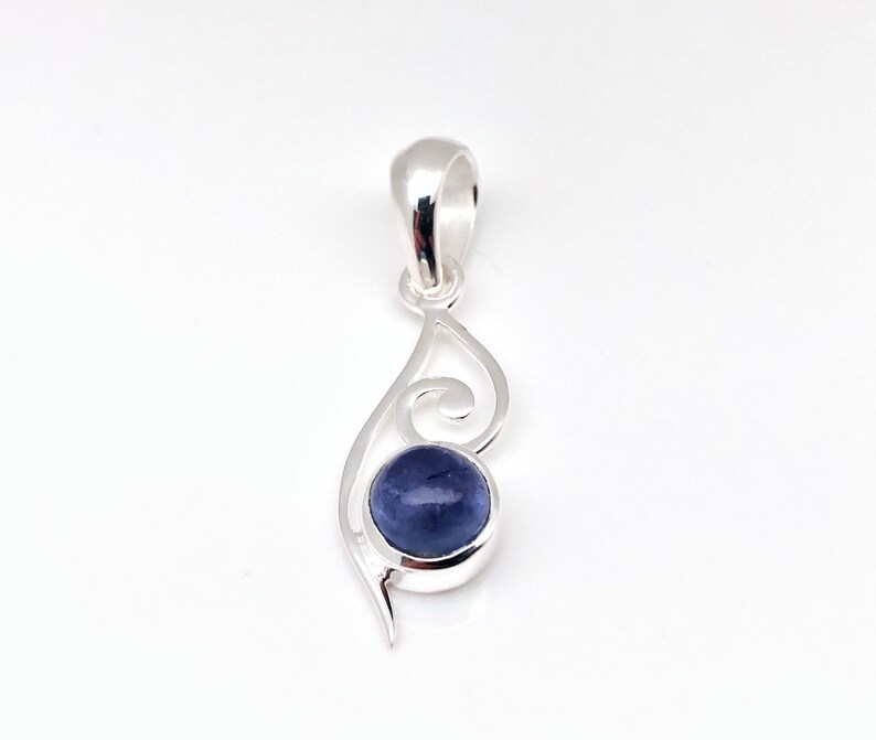Op de afbeelding: Een zilveren hanger met een blauwe edelsteen in een swirl-ontwerp.