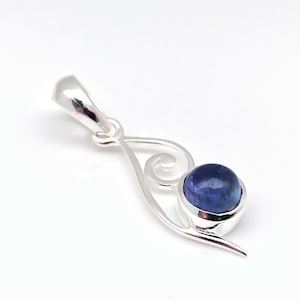 Op de afbeelding: Een zilveren hanger met een blauwe edelsteen in een swirl-ontwerp.