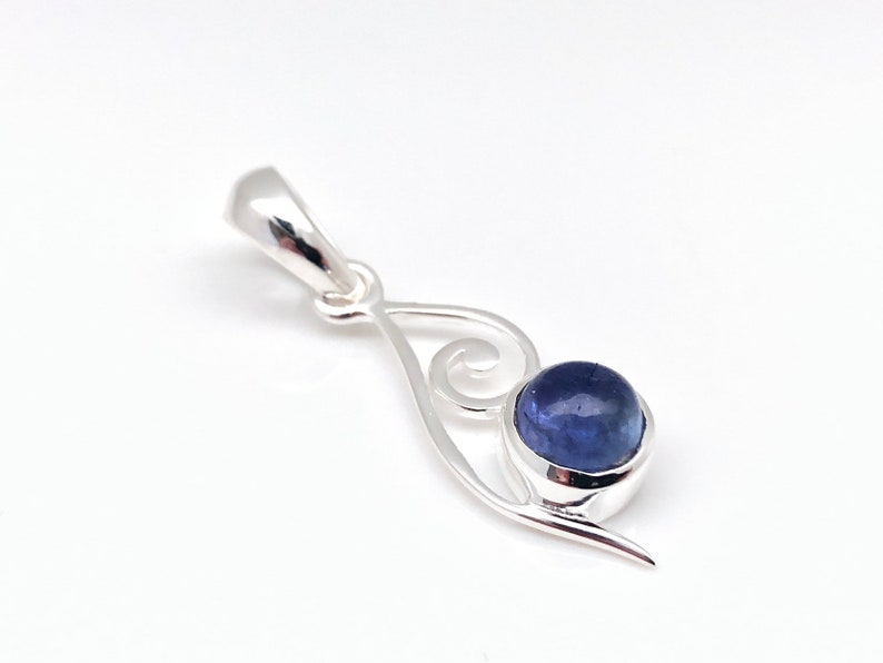 Op de afbeelding: Een zilveren hanger met een blauwe edelsteen in een swirl-ontwerp.