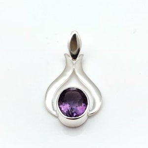 May include: A silver pendant featuring a purple amethyst gemstone set in a delicate, curved design.