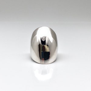 May include: A silver ring with a smooth, rounded dome shape.