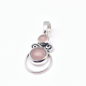 Peut inclure: Un pendentif en argent avec deux pierres de quartz rose. Le pendentif a un design d&eacute;licat et orn&eacute;.