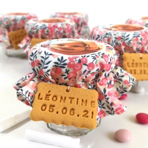 May include: Small glass jars with floral fabric lids and a cookie tag that says "L&eacute;ontine 05.06.21".