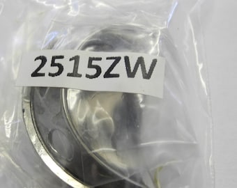 May include: A silver-colored metal sewing machine part with a curved shape and a hole in the center. The part is labeled "2515ZW".