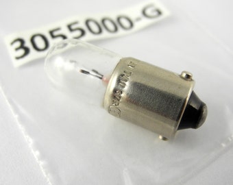 May include: A silver light bulb with a clear glass bulb and a black plastic base. The bulb is labeled "3055000-G" and "6V 1W 12V 2W".