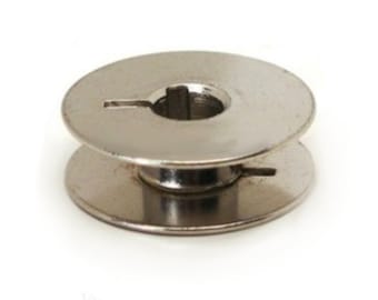 May include: A silver metal bobbin for a sewing machine.